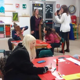 Le mamme preparano il copricapo per i loro figli in vista della sfilata di Carnevale